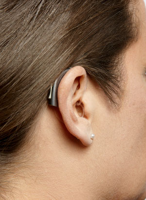 A BTE hearing aid on a woman's ear