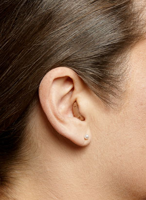 A CIC hearing aid on a woman's ear