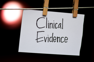 A white card with the words Clinical Evidence hangs from a line by clothes pegs