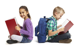 A young boy and girl sit back-to-back reading books