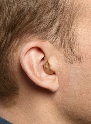 An ITC hearing aid on a man's ear
