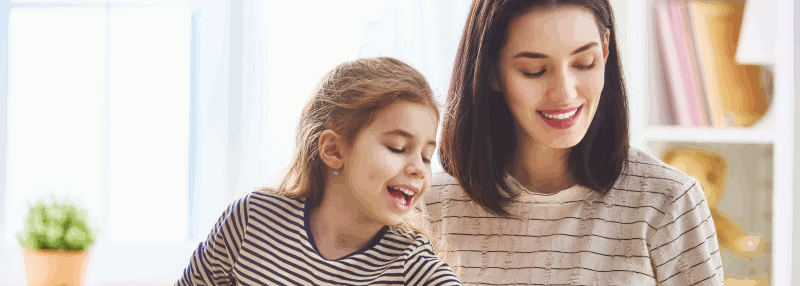 A young girl and her mother work on a puzzle